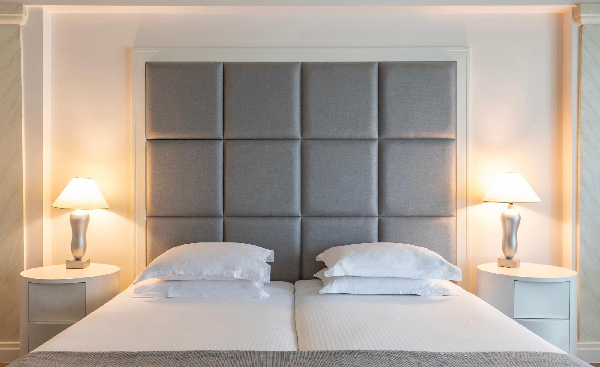 Njv Athens Plaza Hotel Bagian luar foto A bed with a headboard
