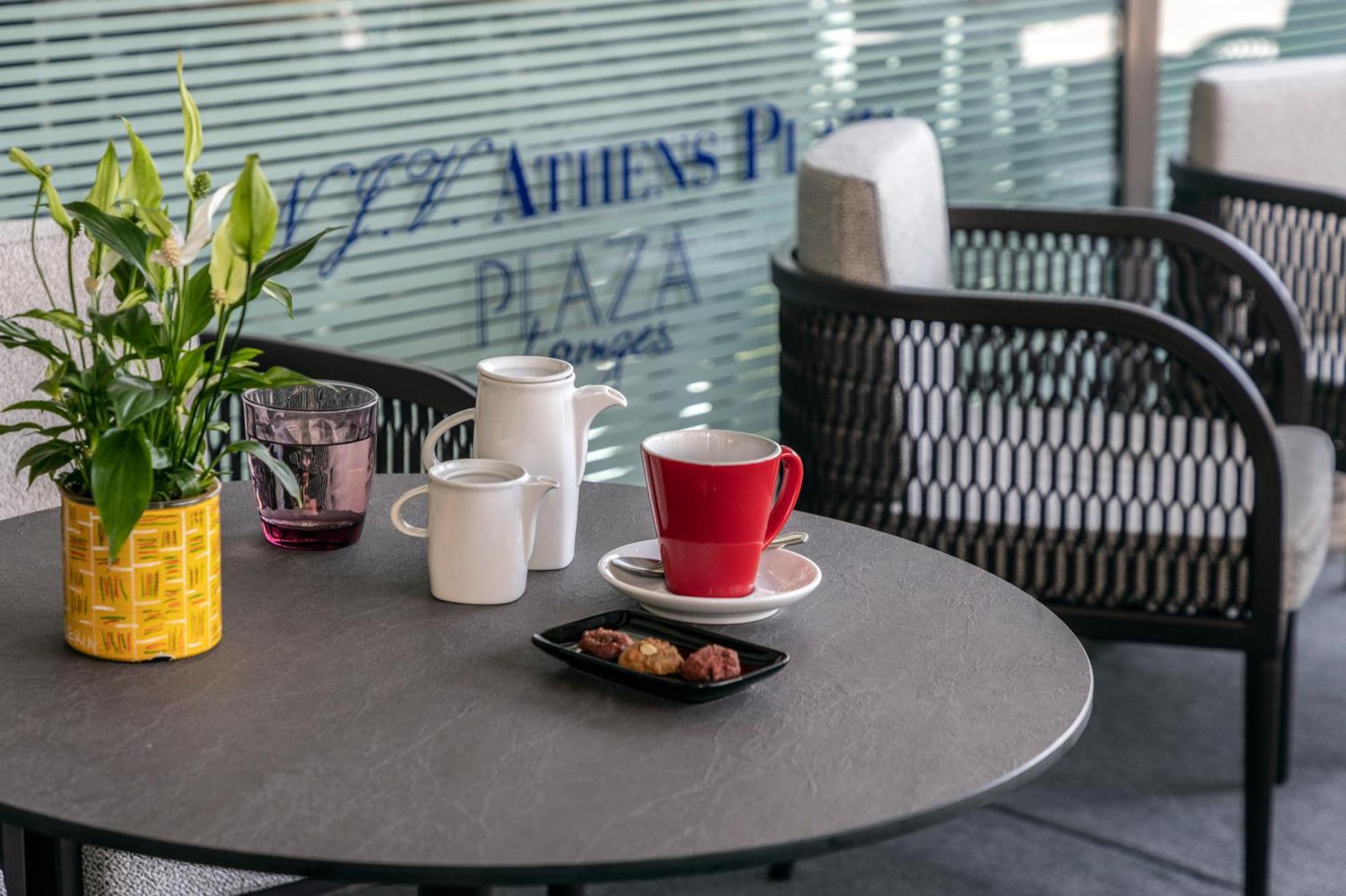 Njv Athens Plaza Hotel Bagian luar foto A coffee table with a red mug